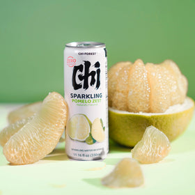 CHI FOREST Pomelo Sparkling Water being poured at a picnic setting.