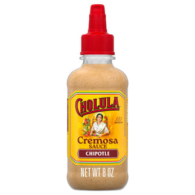 Cholula Chipotle Cremosa bottle drizzling onto tacos for smoky creaminess.