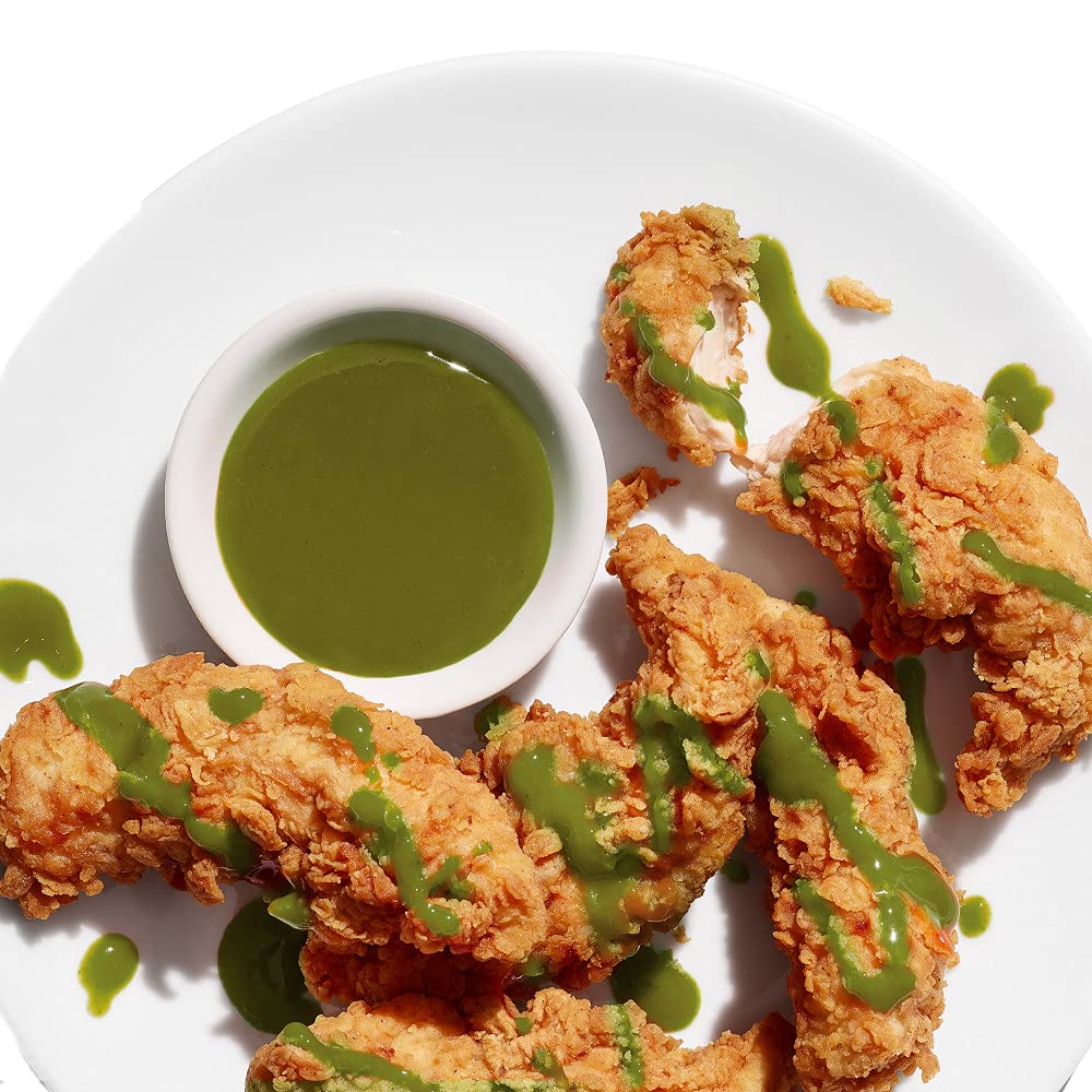 Cholula Green Pepper Hot Sauce on plate with tacos for a zesty finish.