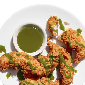 Cholula Green Pepper Hot Sauce on plate with tacos for a zesty finish.