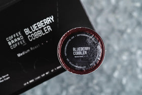 Coffee Brand Coffee Blueberry Cobbler K-Cups pods close-up showing bold blueberry flavor.