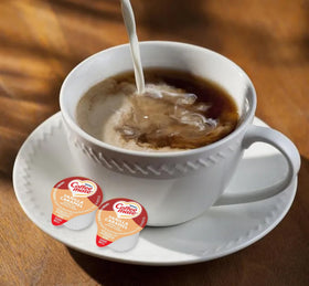 Two Coffee Mate Vanilla Caramel boxes on a kitchen counter.