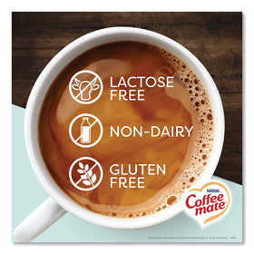 Coffee Mate vanilla oat milk singles on a desk with a coffee mug for office use
