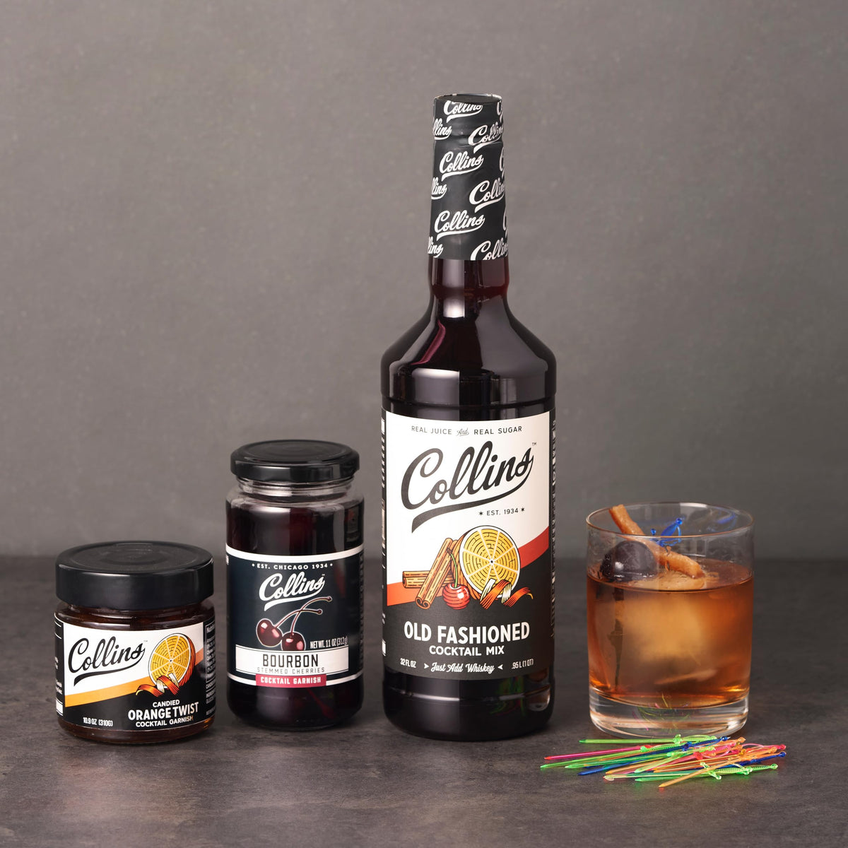 Close-up of Collins cherries and orange twist garnishes on the rim