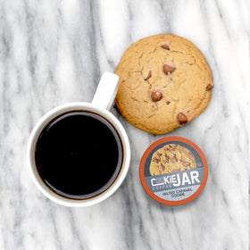 Cookie Jar salted caramel coffee pods being poured into a mug for a creamy hot brew.
