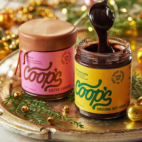 Coop's Original Hot Fudge & Salted Caramel Sauce bottle pouring over ice cream for a luscious flavor boost.