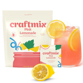 CRAFTMIX Pink Lemonade packets beside a glass of water for a quick flavor boost