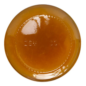 Crofters Apricot Spread closeup in glass jar, bright orange color and shine.