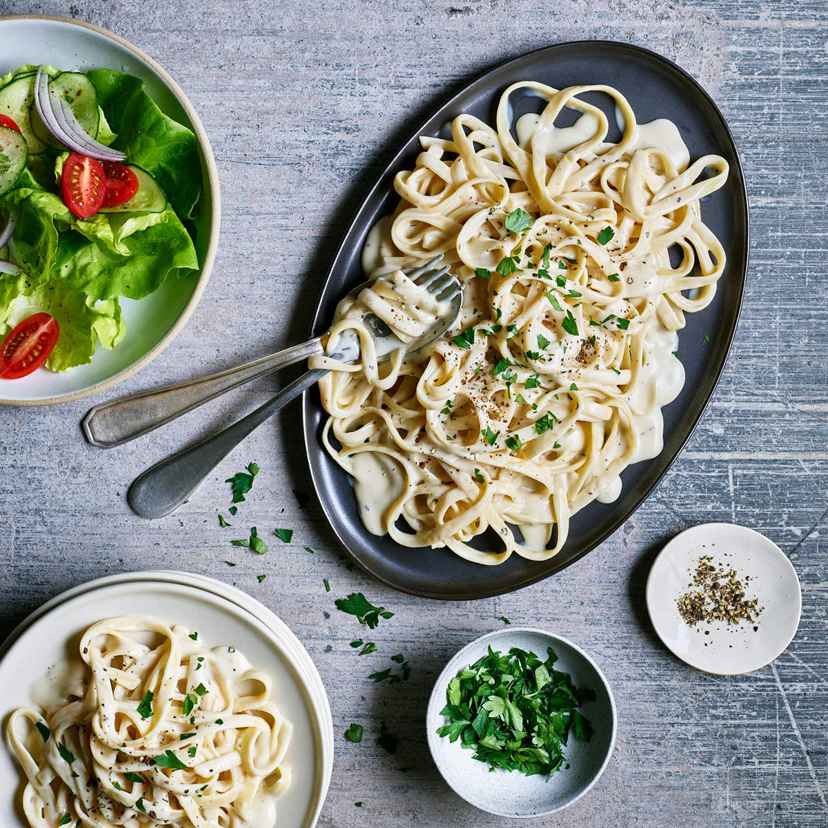 Daiya Alfredo sauce packet being poured over pasta.