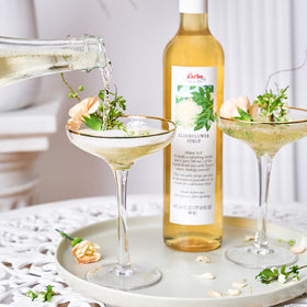 Pouring Darbo elderflower syrup into water for a refreshing drink