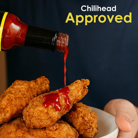 Wings dipping closeup with Dave's Gourmet Insanity adds intense finish