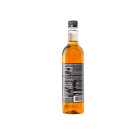 Pouring Davinci Gourmet Classic Caramel Syrup over dessert for caramel drizzle.