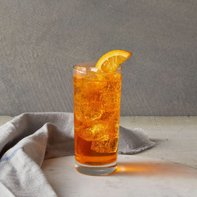 Close-up of syrup bottle pouring into smoothie for consistent citrus taste