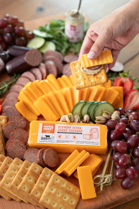 Deli Direct cheddar on a charcuterie board, ideal for entertaining guests.