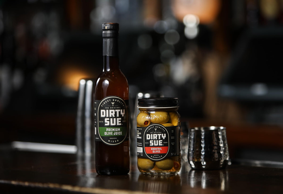 Professional bartender uses Dirty Sue brine in a cocktail setup.