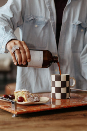 DONA bottle with steam and cup evokes warm chai moments.