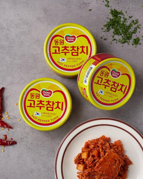 Dongwon tuna cans on shelf, ready-to-heat convenience for busy days.