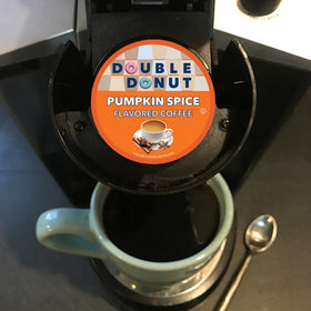 Double Donut Coffee pumpkin spice cup on saucer with autumn decor