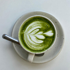 Dr. Weil Matcha Kari powder in vibrant emerald, ideal for whisking into drinks.