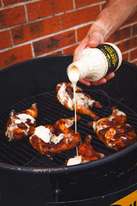 Duce's Wild Alabama White Gold sauce on a sandwich finishing touch