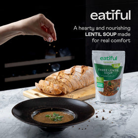 Close-up of green, red, and brown lentils in EATIFUL soup, rich in fiber.