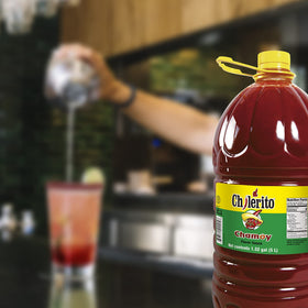 El Chilerito Chamoy Sauce 5L jug with fruits, perfect snack topping.
