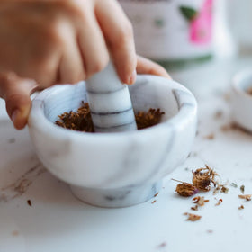 Elanen Naturals tea brewing in a cup releasing floral aroma and color