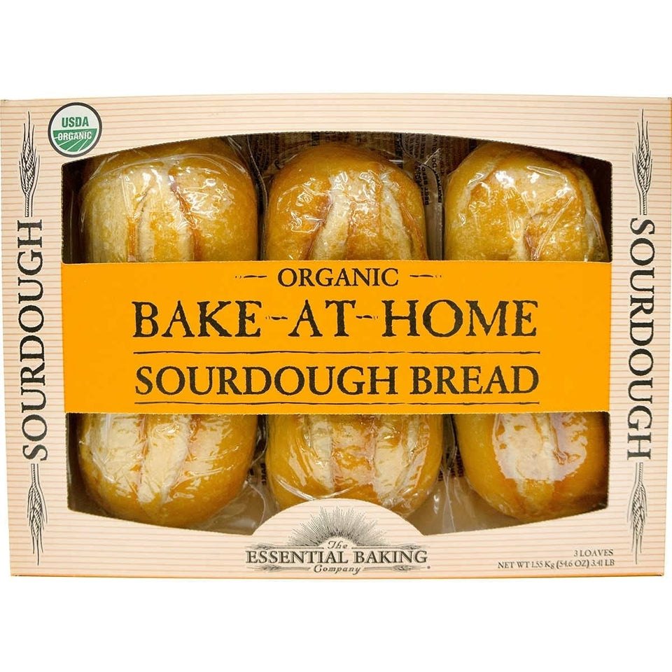 Essential Baking Company Organic Sourdough loaves on a wooden board ready for slicing and dipping.