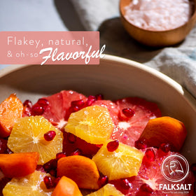 Falksalt pink salt flakes sprinkled over a dish during plating for visual appeal.