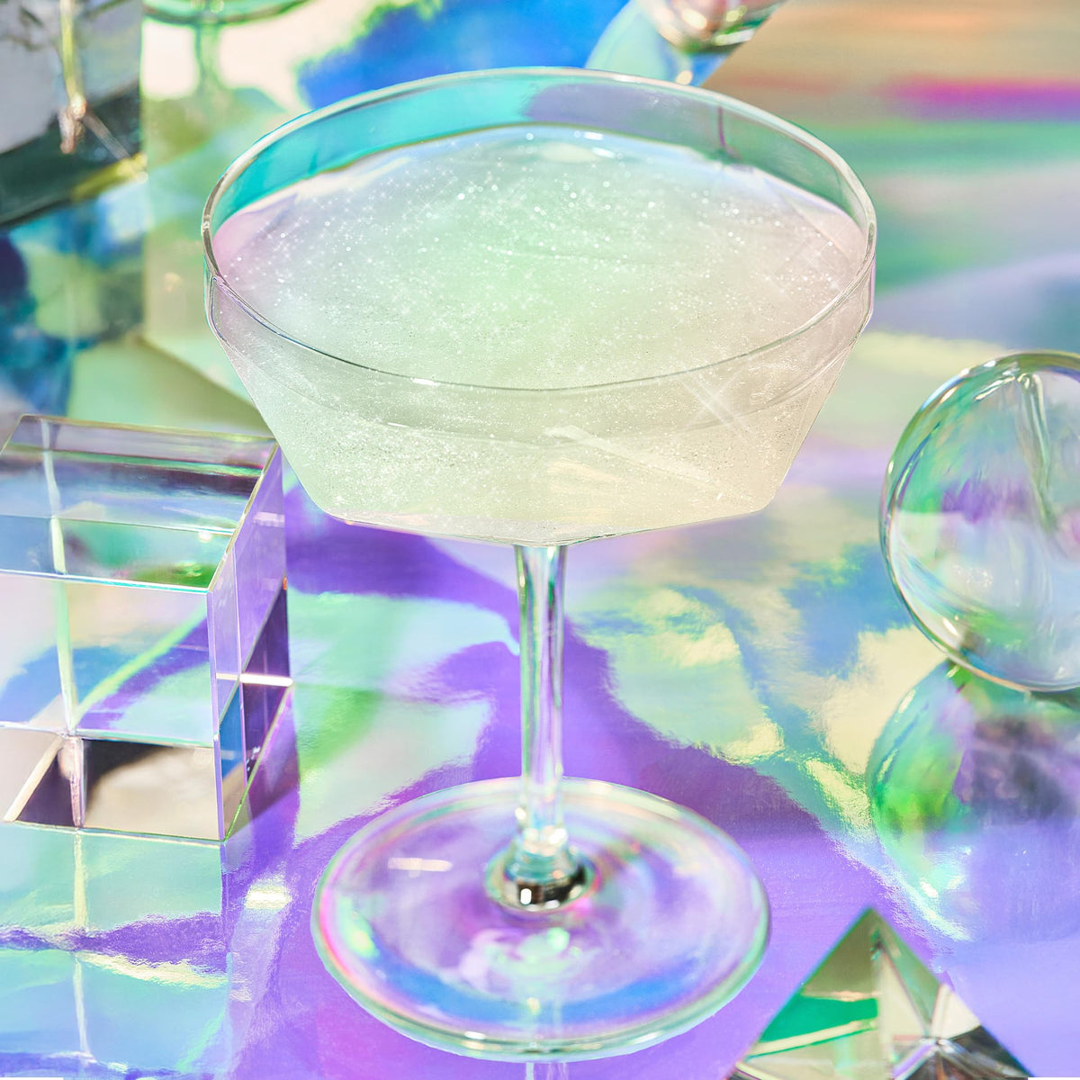 Fancy Sprinkles Moonstone glitter being sprinkled yields iridescent shimmer for two drinks