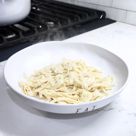 Rustic kitchen scene with Farmhouse Preserve noodles, evoking home-cooked flavor.