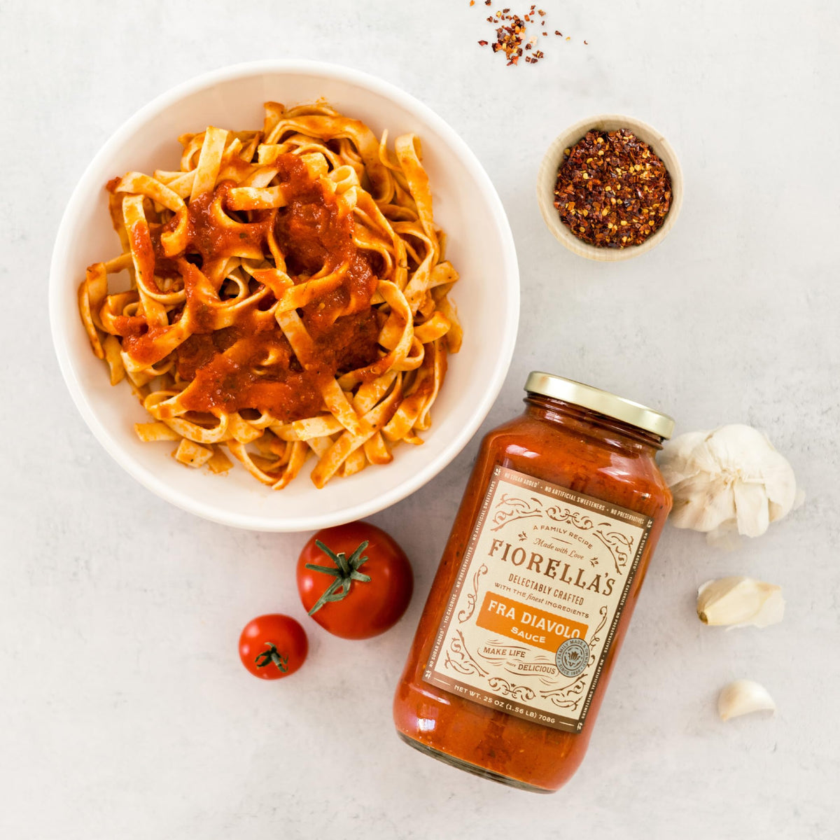 Pouring Fiorella's Fra Diavolo over pasta for a spicy kick