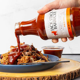 Pouring Fiorella's Jack Stack Original Sauce for glaze and marinades