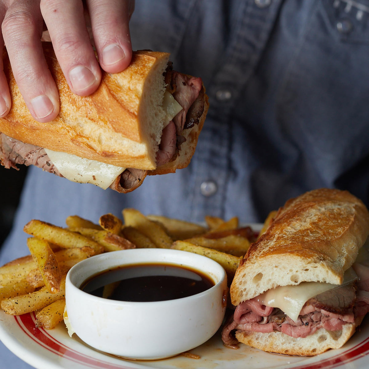 Pouring au jus gravy from Fire & Smoke Society over mashed potatoes
