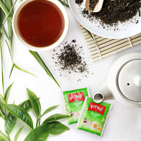 A cup with FITNE infusion bag steeping and fresh honey lemon aroma.