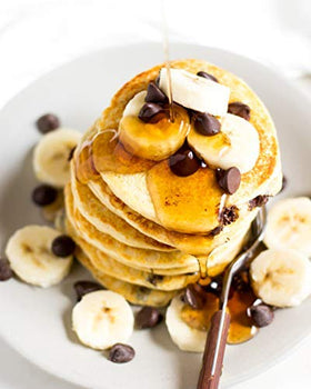 FlapJacked Buttermilk pancakes cooking on a skillet with butter