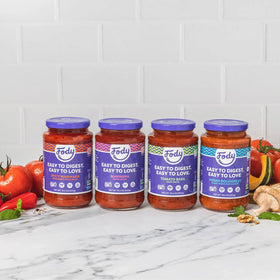 Family dinner with bowls of pasta and Fody marinara sauce.
