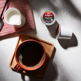 Folgers Black Silk K-Cup pod closeup highlighting bold, smooth flavor.