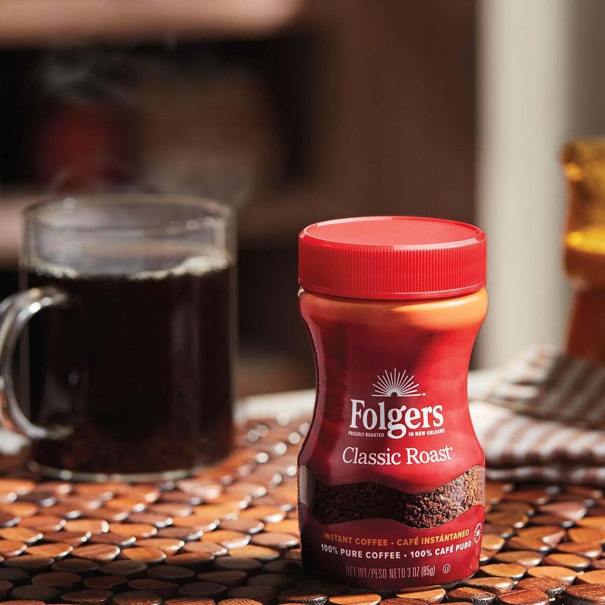 Folgers Classic Roast instant coffee crystals dissolving in liquid, shown stirring.