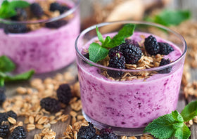 Food to Live mulberries stirred into yogurt bowl for vitamin-rich breakfast.