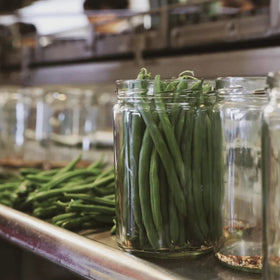 Foster's pickled green beans served with cheese board for vegan-friendly snacking.