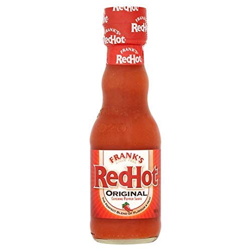 Frank's Red Hot Cayenne Sauce bottle pouring over wings for extra heat.