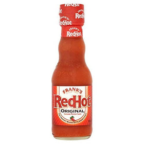 Frank's Red Hot Cayenne Sauce bottle pouring over wings for extra heat.