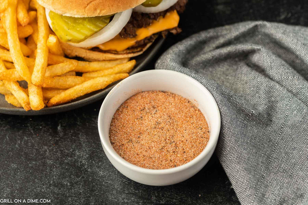 Close-up of Freddy's Sreakhouse seasoning dusting burgers for rich sear.