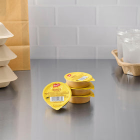 Case of 100 French's Honey Mustard dip cups on shelf.