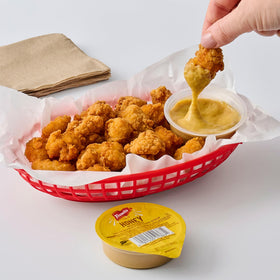 Takeout-ready French's Honey Mustard dip cups ready for orders.