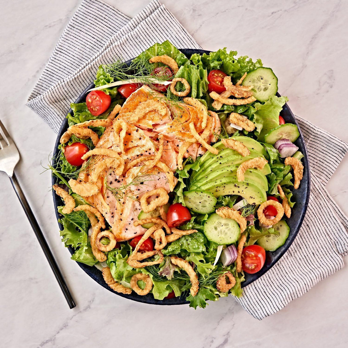 Fresh Gourmet Lightly Salted Crispy Onions on a fresh salad bowl adding crunch.