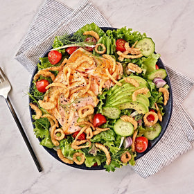 Fresh Gourmet Lightly Salted Crispy Onions on a fresh salad bowl adding crunch.