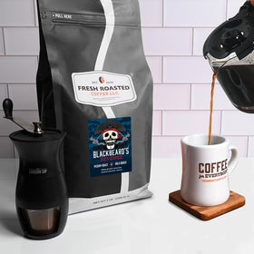 Fresh Roasted Coffee Blackbeard's Revenge whole-bean with scoop, aroma preserved.