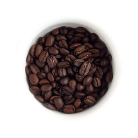 Fresh Roasted Coffee dark Sumatra Mandheling whole beans on a wooden surface ready to grind